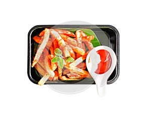 Top view tasty french fries with ketchup on black plate , isolated on white background with clipping path