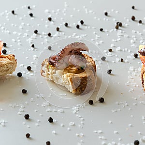 Top view of tasty Italian appetizers -  bruschetta with raw tomatoes and octopus tentacles, on slices of toasted baguette