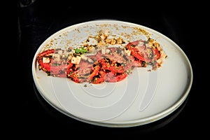 top view on tasty sliced tomato decorated with assorted herbs