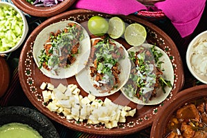 Top view of tasty tortillas with meat next to raw potato cubes and sliced lime
