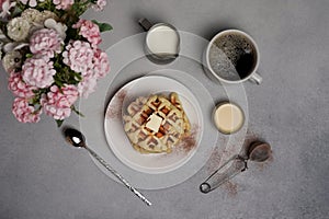 Top view of tasty Waffles Plate, Caramel Sauce, Coffee Cup, Milk, dessertspoon