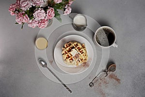 Top view of tasty Waffles Plate, Caramel Sauce, Coffee Cup, Milk, dessertspoon