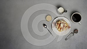 Top view of tasty Waffles Plate, Caramel Sauce, Coffee Cup, Milk, dessertspoon, strainer