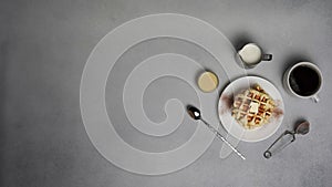 Top view of tasty Waffles Plate, Caramel Sauce, Coffee Cup, Milk, dessertspoon, strainer