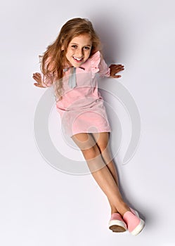 Top view of a teenager girl in a casual pink dress and gym shoes. The style of youth and adolescents. On a light background.