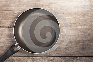 Top view teflon pan on wooden plank