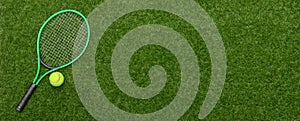 Top view of tennis racket and ball of green grass. Horizontal sport poster, greeting cards, headers, website