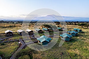 Top view of tent camp in the African savannah. Tents on the background of Mount Kilimanjaro in the forest in Africa