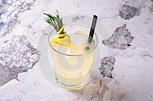 Top view tequila, lemon, rosemary fizz. Alcoholic drink in glasses with fresh herbs on a gray background, selective