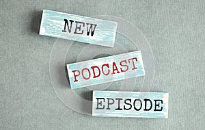 Top view of text NEW PODCAST EPISODE on wooden block  podcasting