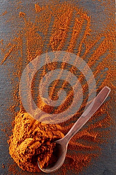 Texture background. Red chilli pepper powder mixed with wooden spoon. Top view
