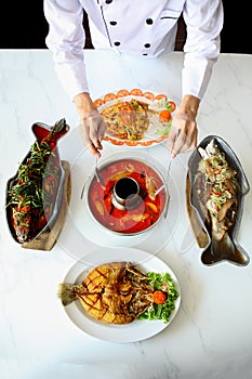 Top view of Thai Asian cuisine chef preparing Tom yum goong and seafood dishes.
