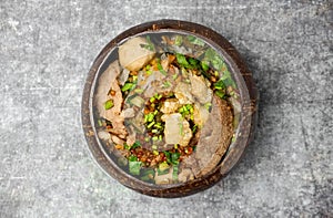 Top view Thai noodle soup with pork and meatballs in coconut shell