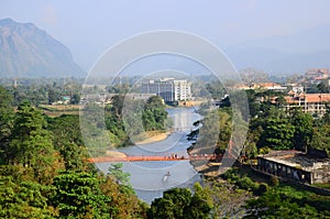 The top view at Tham chang cave can see tourists walking across the orange suspension bridge over the Song River, Vang Vieng Laos.