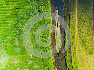 Top view of a thin river and fields around it.