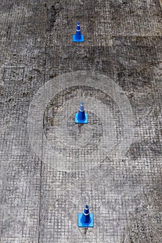 Top view of three blue traffic cones on asphalt road for traffic