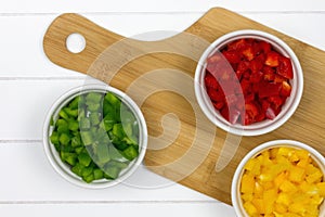 Top-view of three bowls filled with sliced paprikas