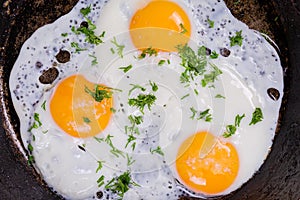 Top view of three fried eggs in the frying pan
