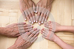 Top view of three generations of women put hands together