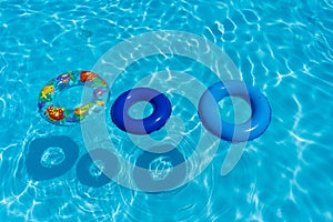 Top view of three inflatable buoys floating on water.