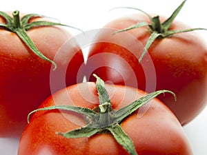 Top view of three red tomatoes on a white background photo