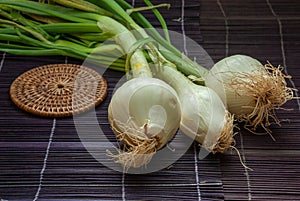 Top view of three scallions on purple mat