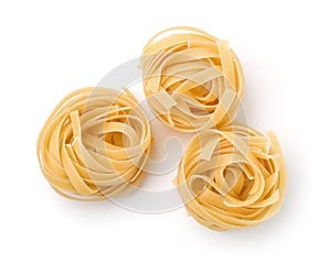 Top view of three uncooked tagliatelle pasta nests