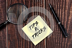Top view of Tips and Tricks text on adhesive note