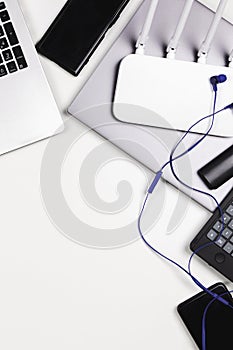 Top view to old laptop computer, mobile cell phone, many used electronic gadgets devices on white table. Planned