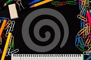 Top view to school supplies background with clips, pencil, eraser and lined page of notpad