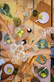 Top view of toasting wine above wooden table