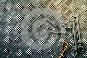 Top view of tools on industrial metal checker plate. Metal checkerplate for anti skid. Nut, bolts, and hex key on metal sheet