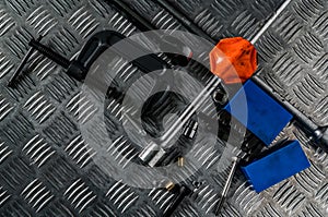 Top view of tools on industrial metal checker plate. Metal checkerplate for anti skid. Nut, bolts, and hex key on metal sheet