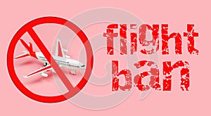 Top view of a toy plane with a ban sign and the inscription flight ban on a pink background. Closed airspace over the state