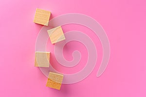 Top view of toy wooden blocks on pink