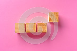 Top view of toy wooden blocks on pink