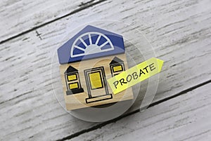 Top view of toy wooden house and sticky note written with Probate on white wooden background