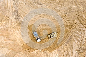 Top view of track bulldozer leveling soil before road construction