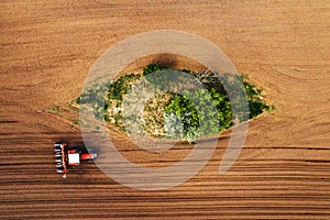 Top view of tractor with seeder from drone pov