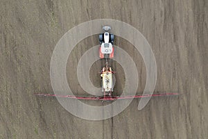 Top view of tractor spraying grain on a field