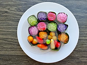 Top view traditional colorful sweet Thai desserts on a white plate