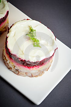 Top view of traditional layered fish salad with beetroot, potato, onion, herring and mayonnaise. Salad herring under fur coat