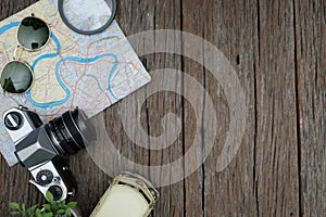 top view travel concept with retro camera films, glasses and othet items on wooden background