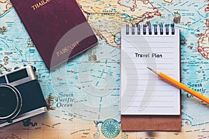 Top view of Traveler notepad for planning travel trips vacations on the world with old camera and passport,