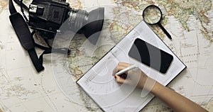 Top view traveler`s hands picking a country for travelling at white wooden desk Travelling concept