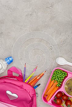 top view of tray with kids lunch for school, bag with pencils