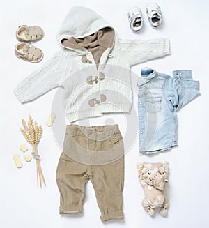 Top view trendy look of baby boy clothes with toy in countryside