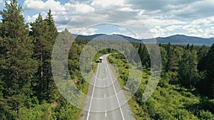 Top view of truck driving along highway in forest area. Scene. Truck is driving along highway among green forest on