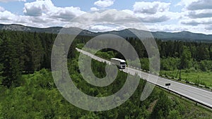 Top view of truck driving along highway on summer day. Scene. White truck is driving on country highway with green