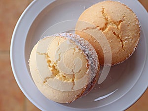Top view of two Alfajores, traditional Latin American sweets served on a white plate